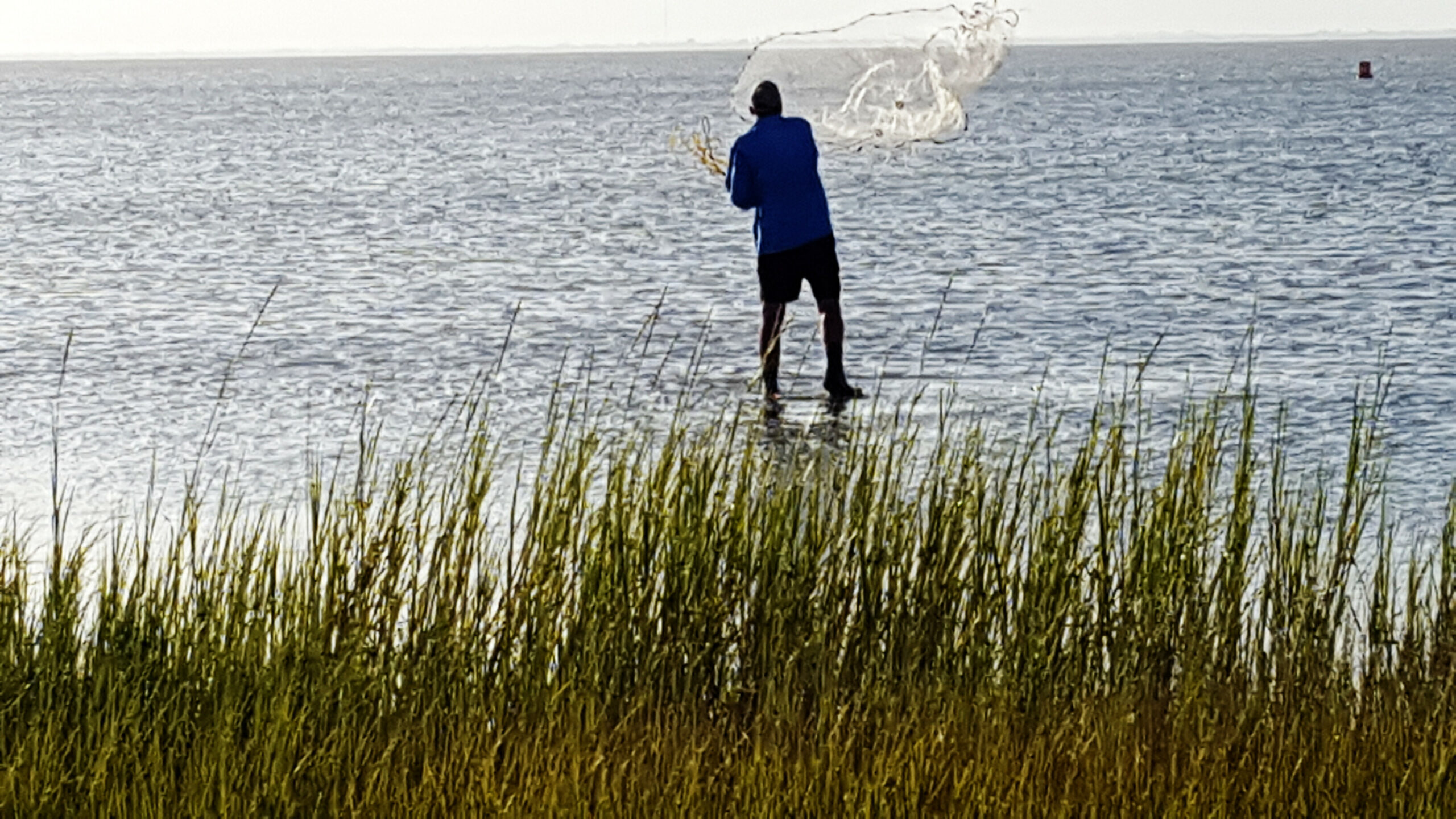 surf fishing for speckled trout - Ken Kuhn throwing a cast net for live bait