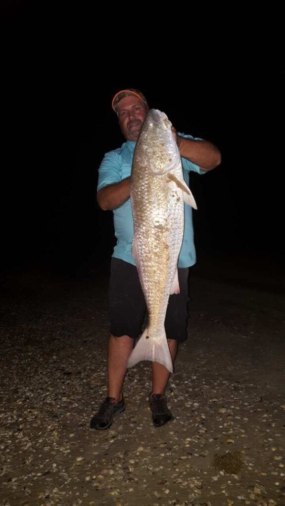 Kevin Stonebarger with a giant of a bull redfish on Matagorda Beach Texas - What is beach fishing?