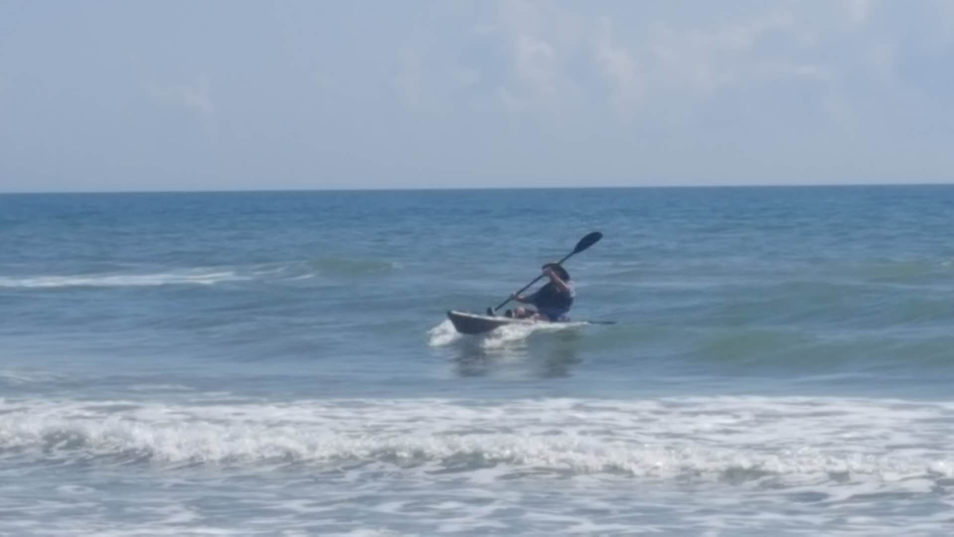 kayak riding the surf back to the beach