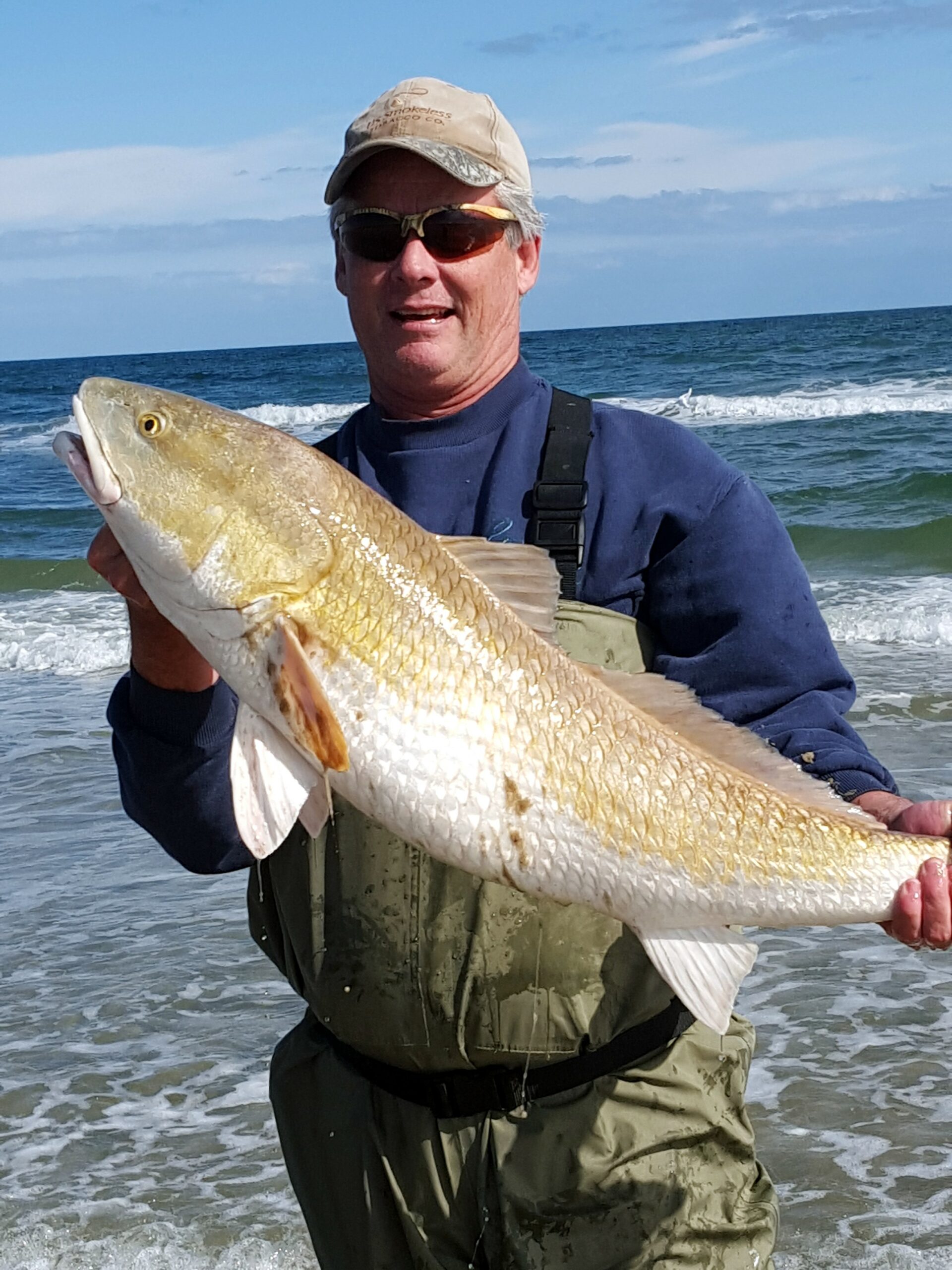 Author with a bull redfish caught using live finger mullet in the surf