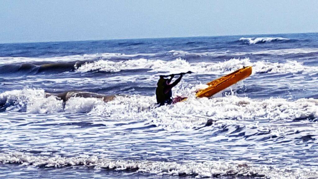 Kaysi Tidwell paddling out in the Padre Island National Seashore surf in her saltwater kayak