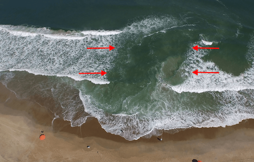 aerial photo of a suck out or rip current along the beach