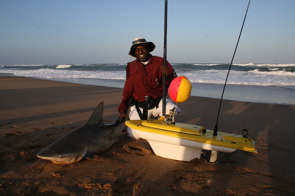 Man with a shark caught from the beach using the Aqua Cat Turbo X Bait Boat