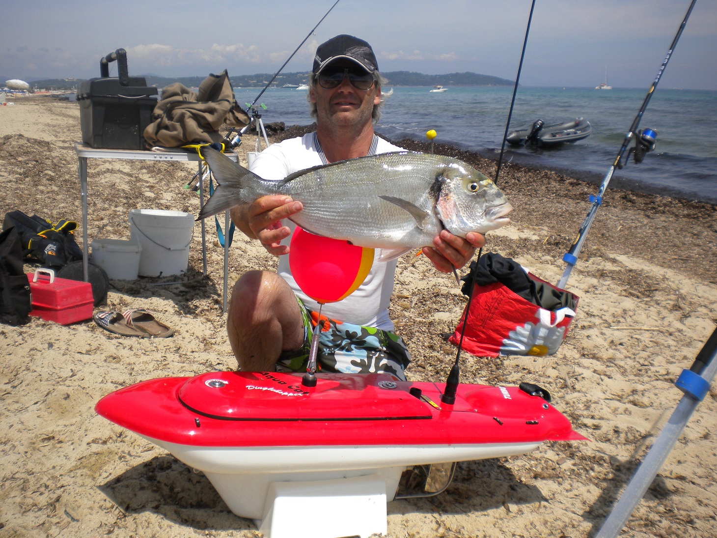 fisherman with a fish he caught using the Aqua Cat Turbo X RC Bait Boat