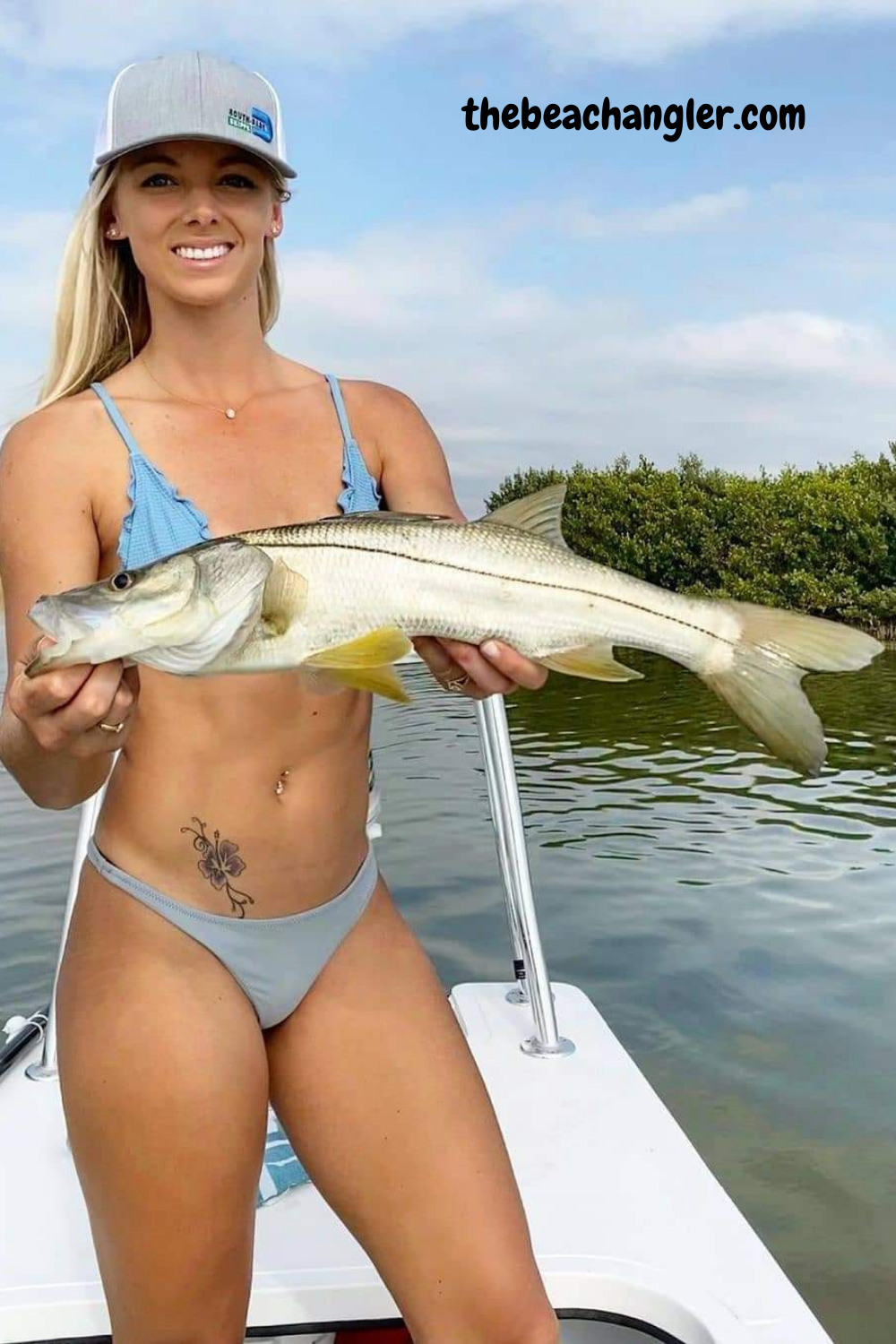Lady with a nice snook getting all her tackle there with a surf fishing tacle bag