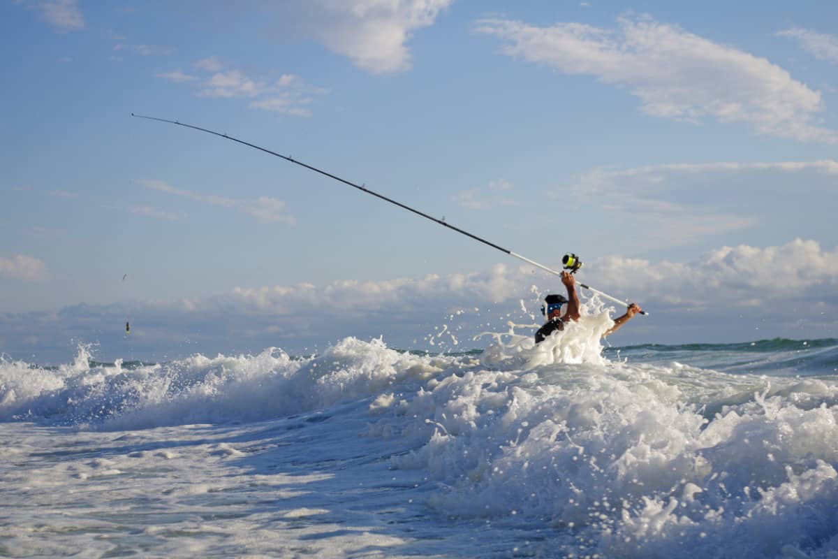 surf fisherman wading into some big waves and rough water.