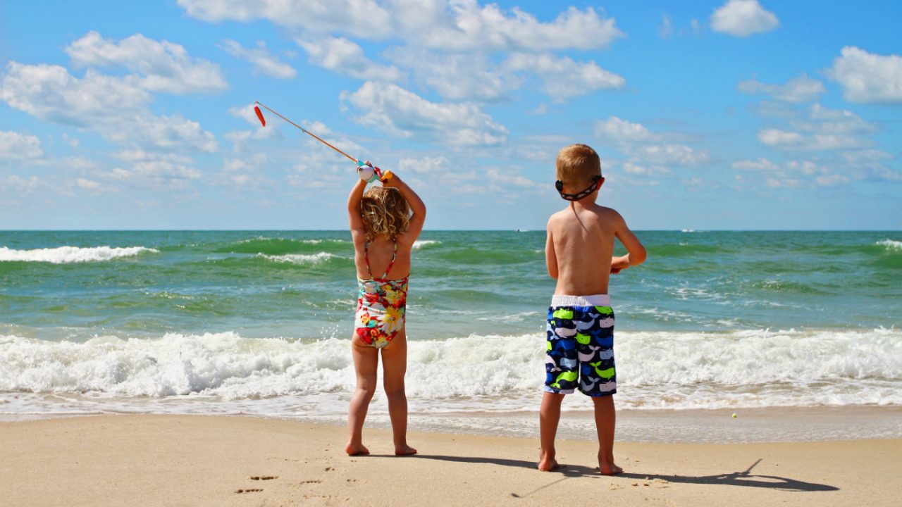 9 Essential Tips for Surf Fishing with kids - young boy and his little sister fishing in the surf.