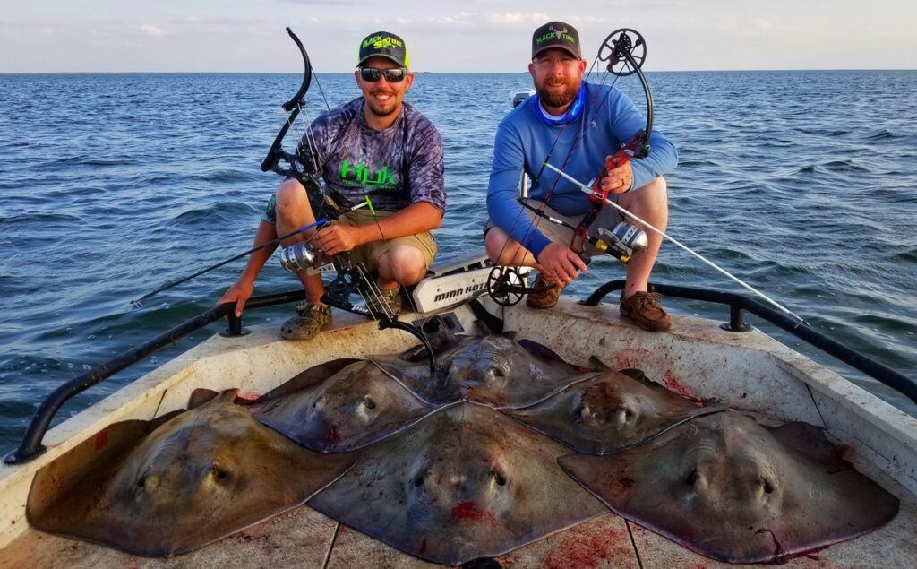 bowfishing how to for beginners - two bowfishermen with a nice haul of large sting rays taken with their bow fishing equipment.