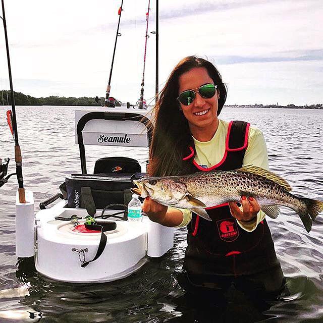 Seamule wade and beach fishing carts review - Young lady angler holding a nice speckled trout and using her loaded seamule wade fishing cart