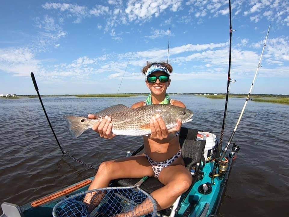 Young lady with a nice slot redfish caught from her fishing kayak
