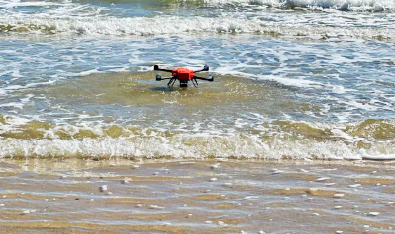 SwellPro Fisherman MAX fd2 fishing drone taking off from the water in the surf