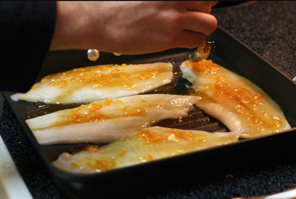 How to catch Gulf Kingfish - picture of gulf kingfish, aka whiting, fillets being brushed with a citrus glaze prior to grilling