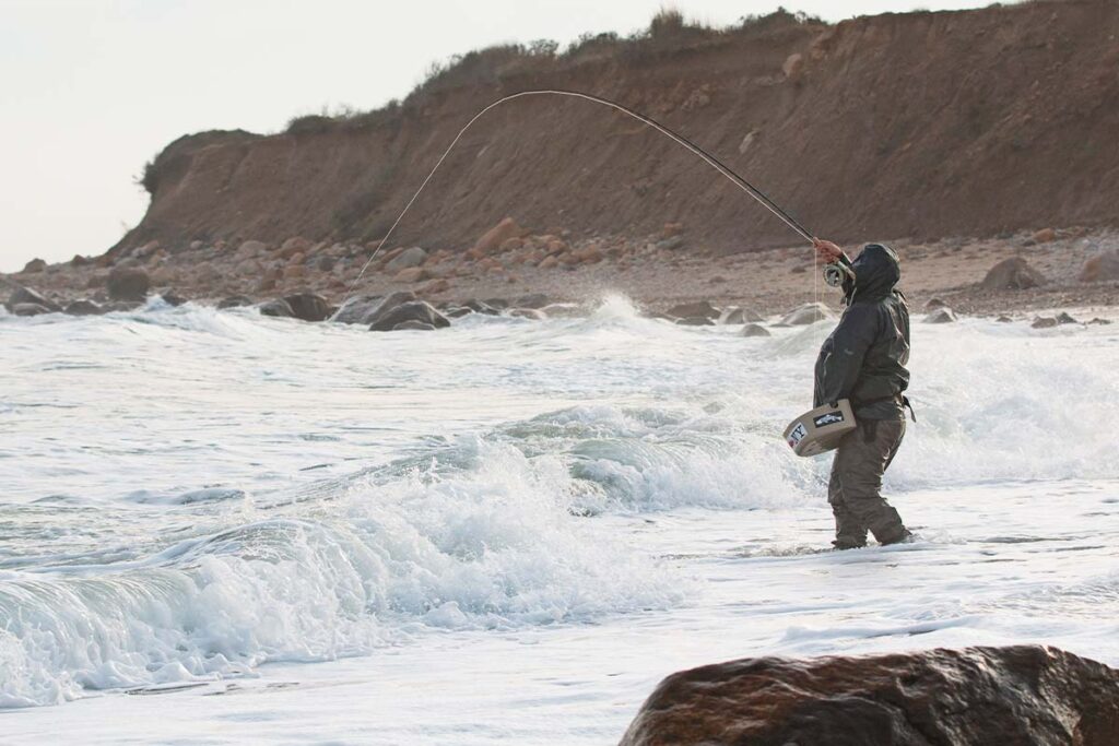 Fly angler fishing the surf in Montauk, New York USA