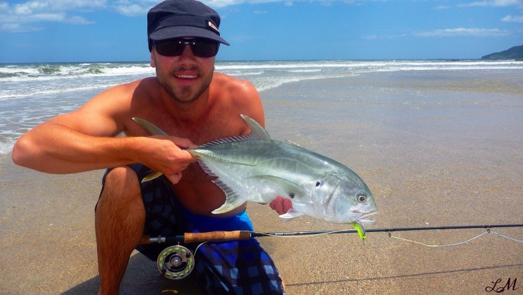 Fly fisherman with a jack crevalle caught from the beach in Costa Rica