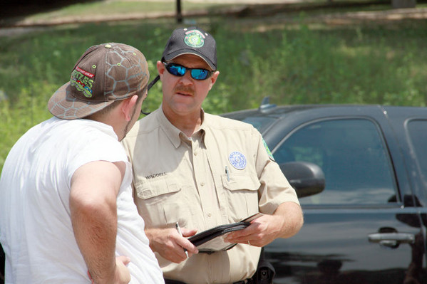 Texas Parks and Wildlife Game Warden giving an angler a citation