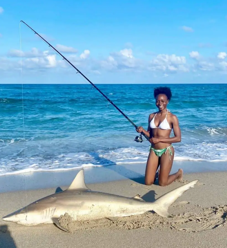 Young lady angler with a large shark caught in the Florida surf