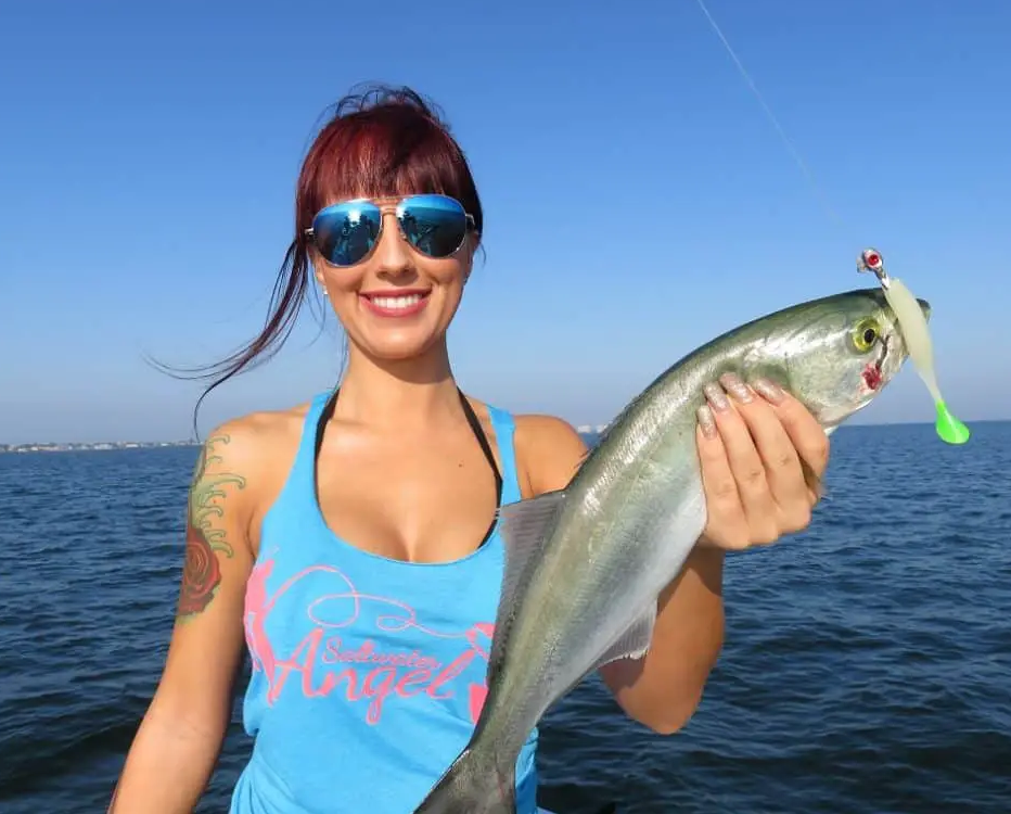 Lady with a bluefish caught using a soft plastic lure