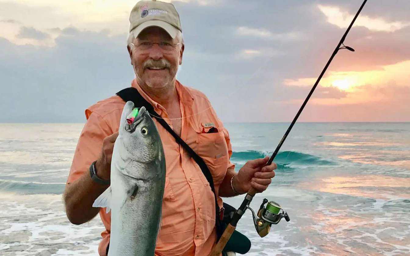 Angler holding a nice bluefish caught on a topwater lure from the surf