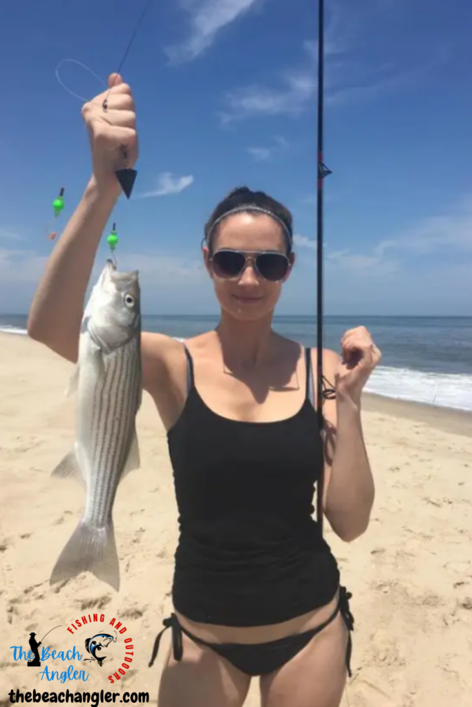 Surf Fishing on Long Island - Lady angler holding up a nice striped bass caught while surf fishing on Long Island