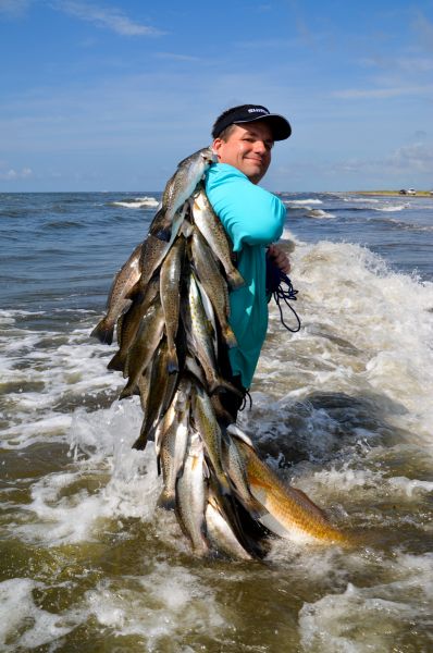 Surf fishing in Louisiana - Surf angler with a nice stringer of speckled trout and redfish caught from the Lousiana surf