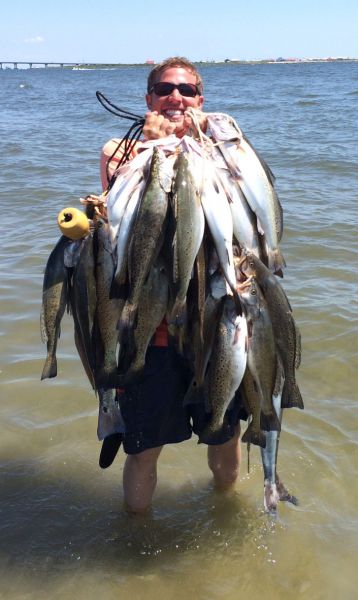Surf fishing in Louisiana - Surf fisherman with a very heavy stringer of speckled trout caught from the Louisiana surf