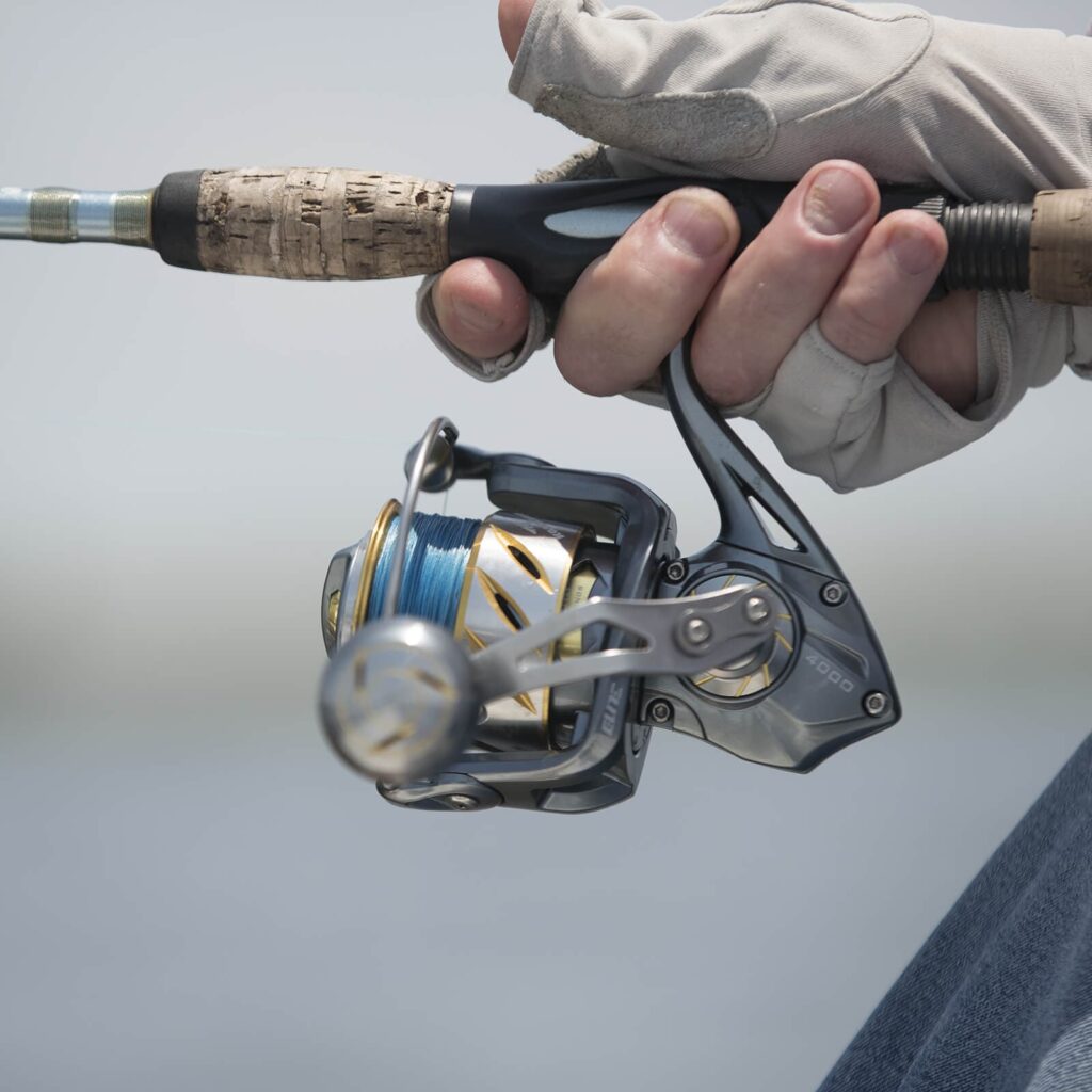 Kastking Kapstan Elite saltwater spinning reel in the gloved hand of a angler ready to make a cast
