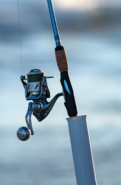 Kastking Kapstan Elite 8000 saltwater spinning reel on a rod in a sand spike on the beach