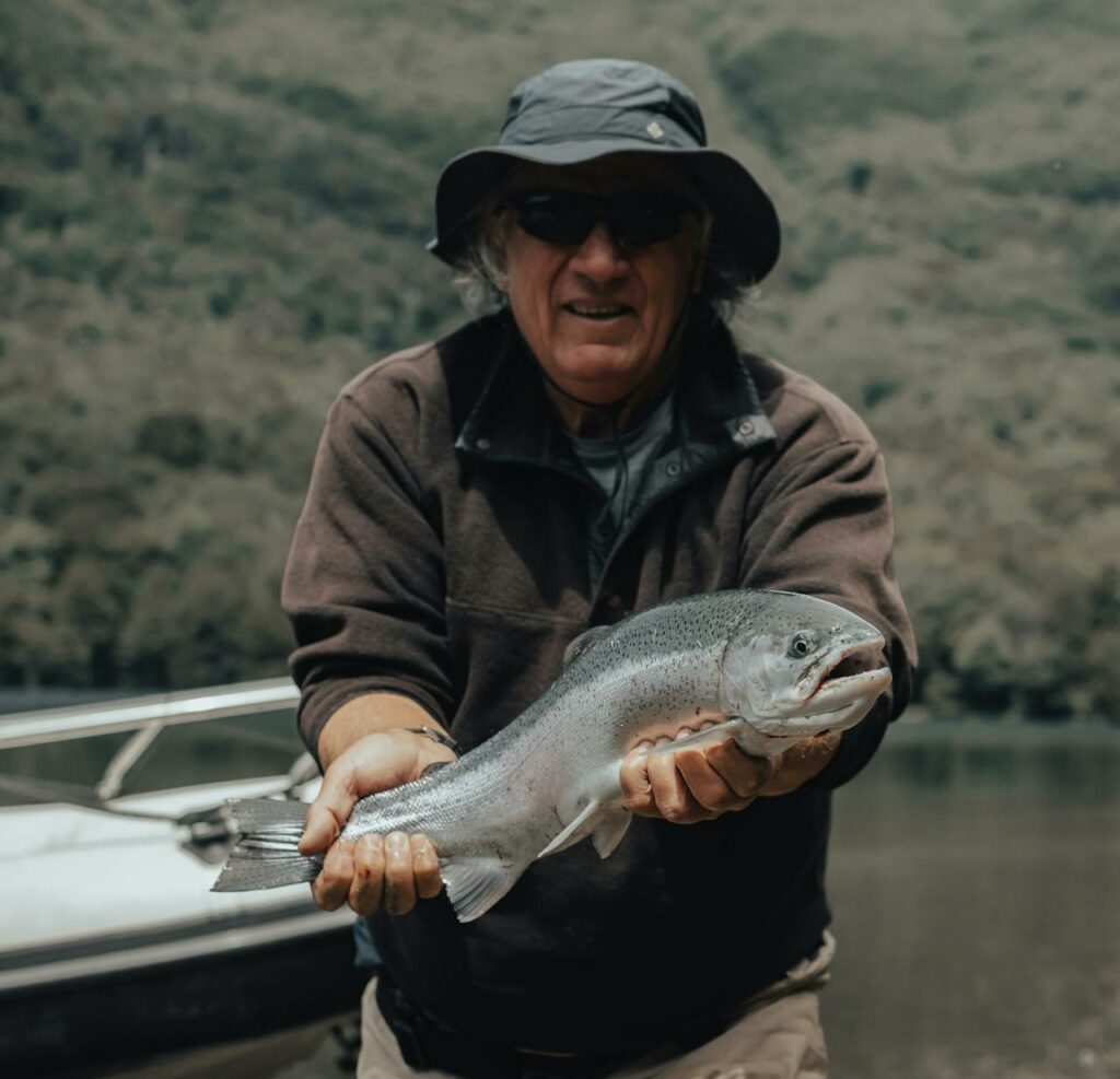 surf fishing for steelhead - angler holding a nice steelhead