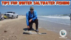 winter saltwater fishing - Ken Kuhn kneeling on the beach with a nice red drum caught from the winter surf.