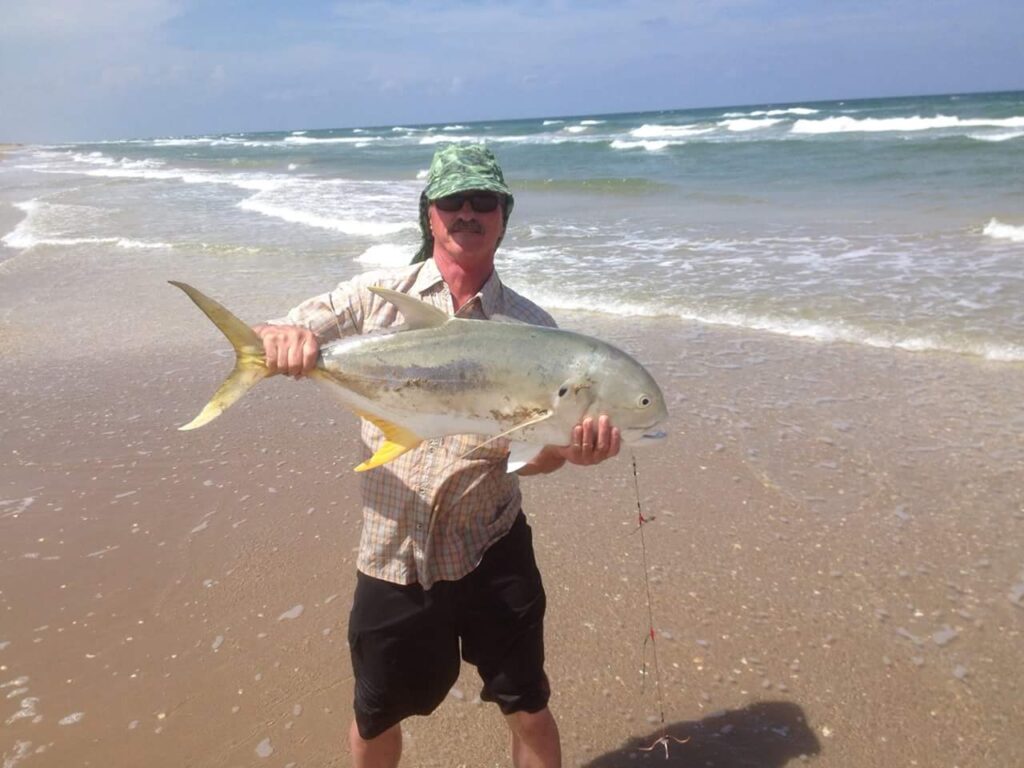 Gerry Gerwick with a nice jack crevalle with the surf and beach in the background.