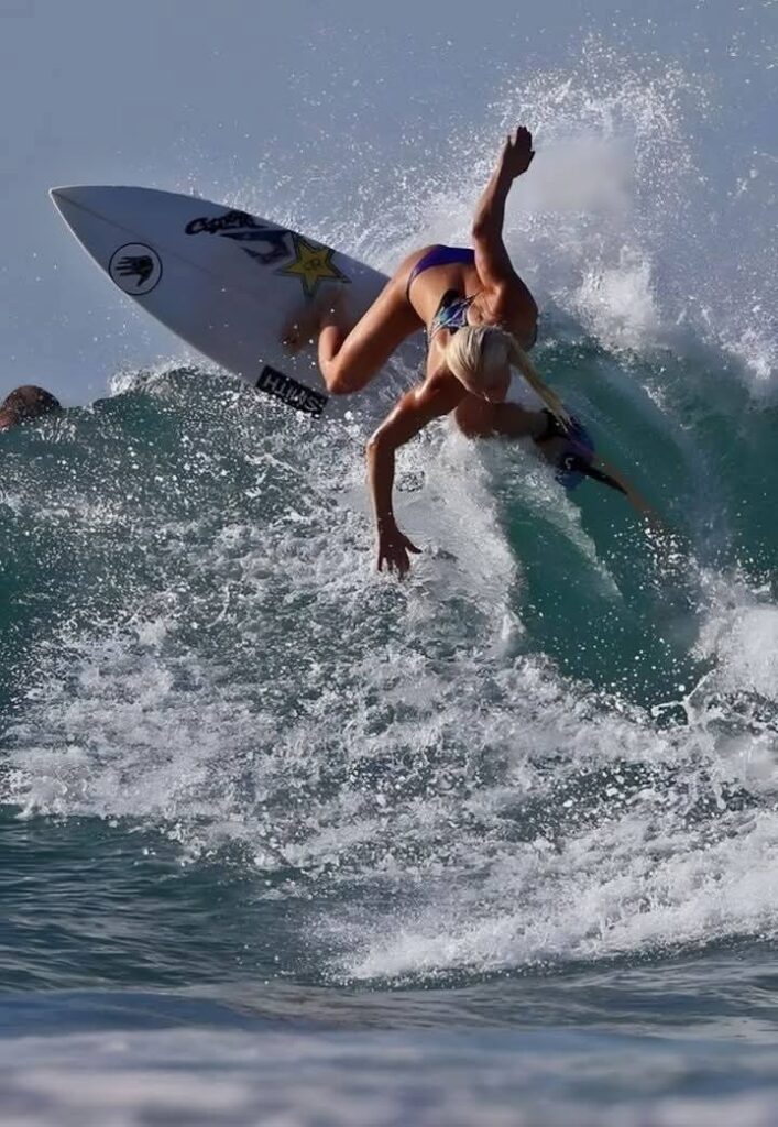 Lady surfer surfing on a large wave