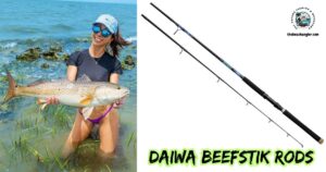 Daiwa Beefstik Surf Rods featured image showing a lady angler kneeling in the shallows with a large red drum.